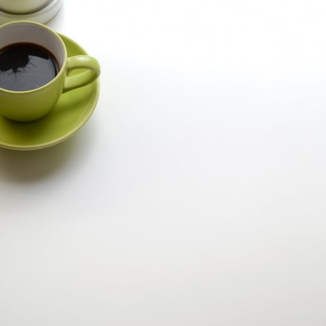 mug and laptop on corner of white table